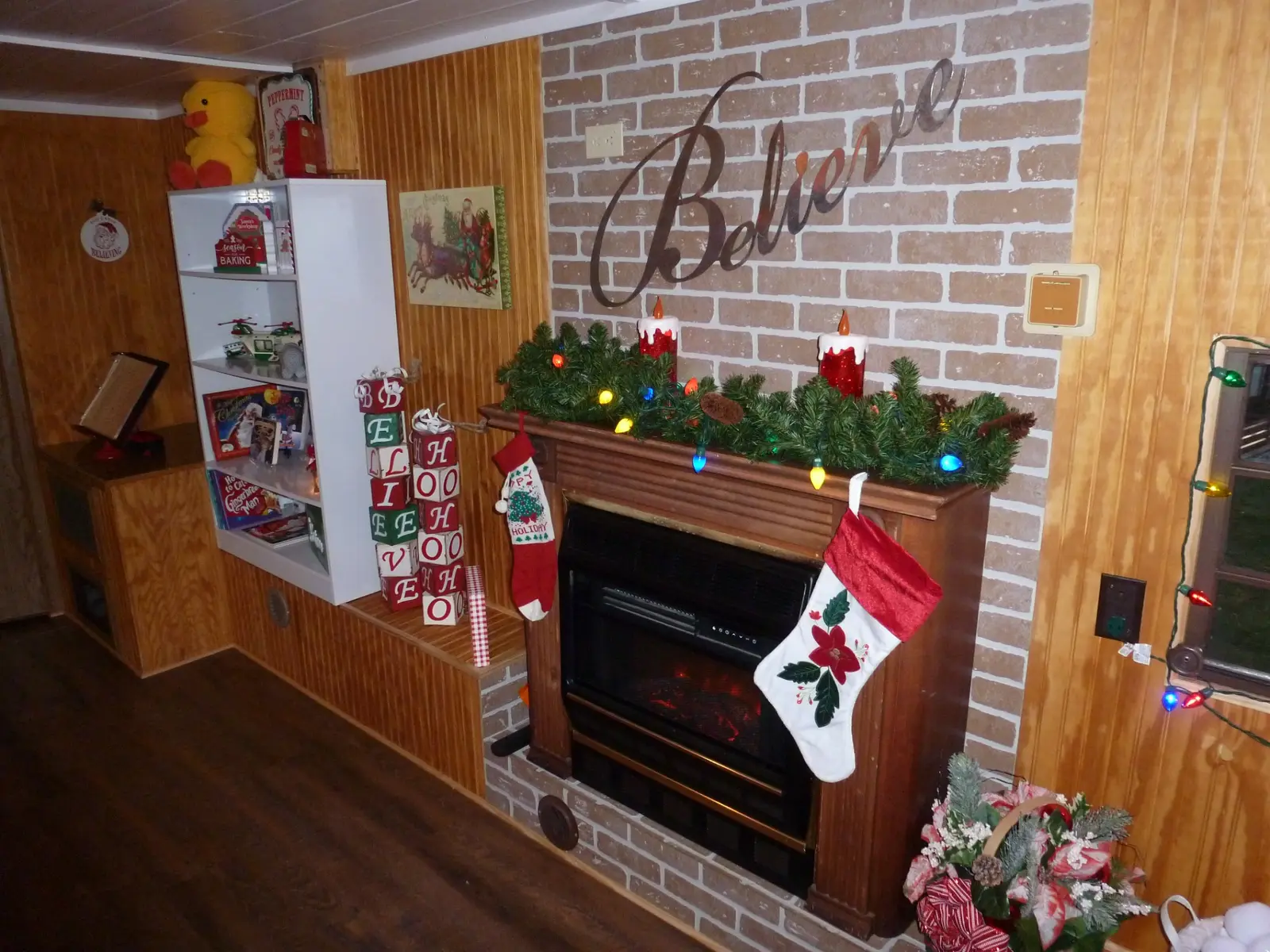 Decorated fireplace and Believe sign inside Santa's Cabin