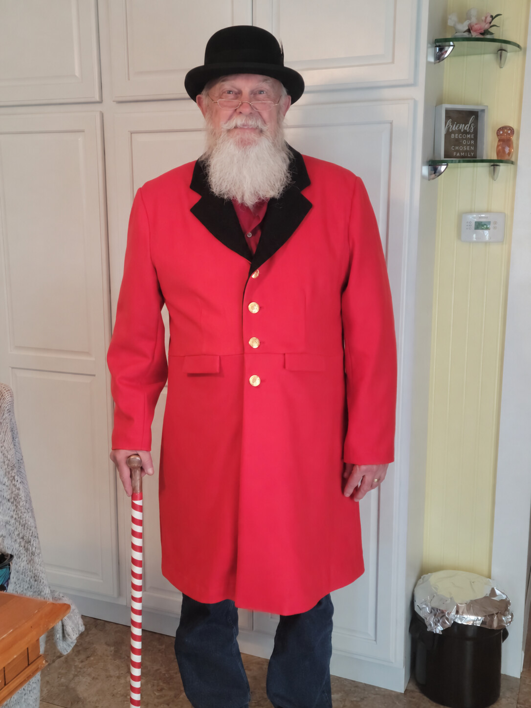 Santa Skip wearing a red Victorian coat, black bowler hat and carrying a striped cane