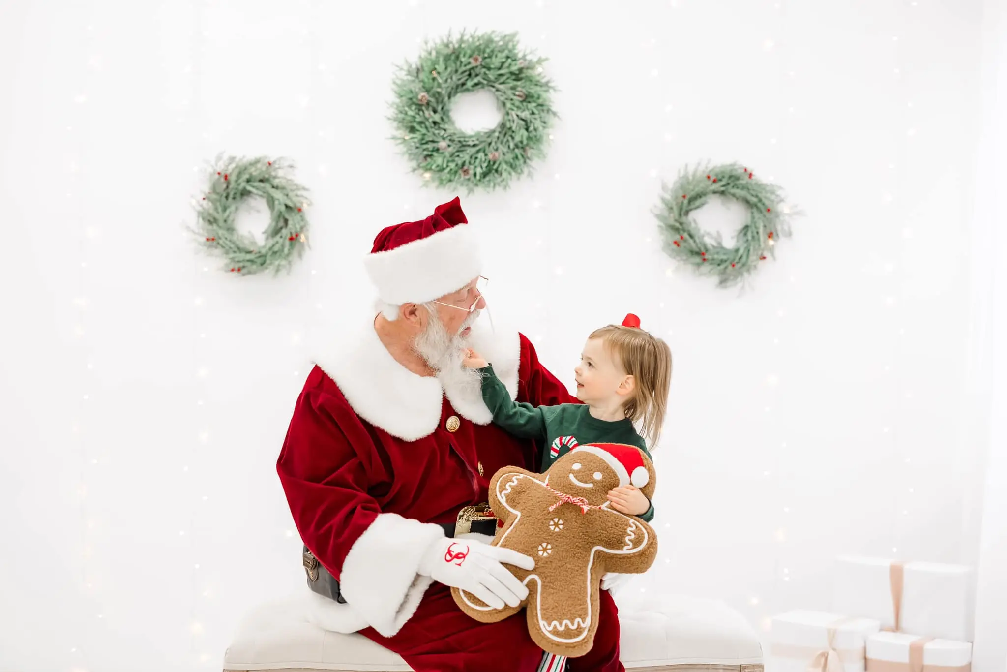 Santa Skip sharing a joyful Christmas moment with a child holding a gingerbread friend