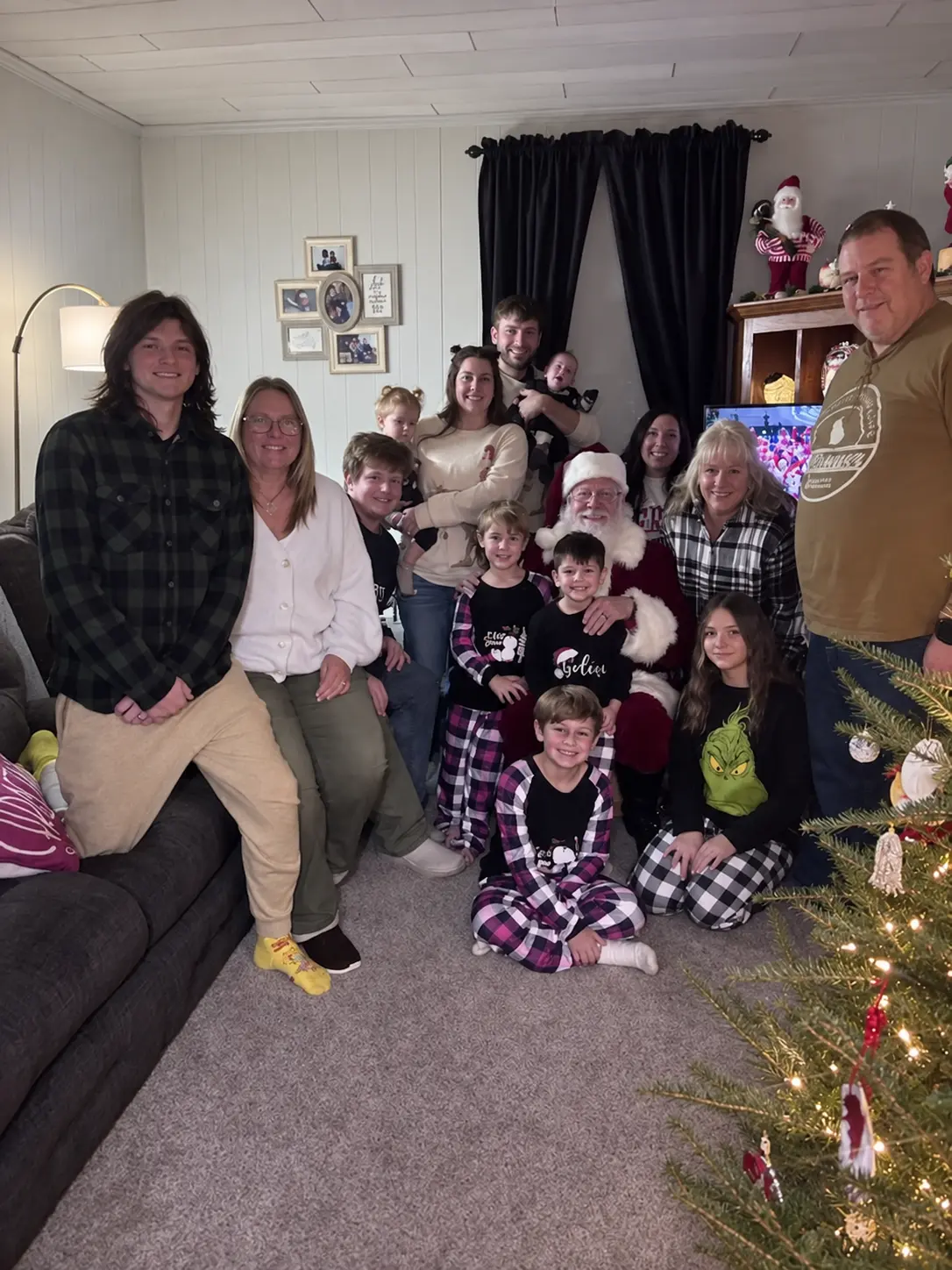 Santa Skip surrounded by a family during a home Christmas visit